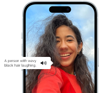 iPhone 15 mostrando un anuncio de la Voz en Off que describe una fotografía como: una persona con cabello negro ondulado riendo